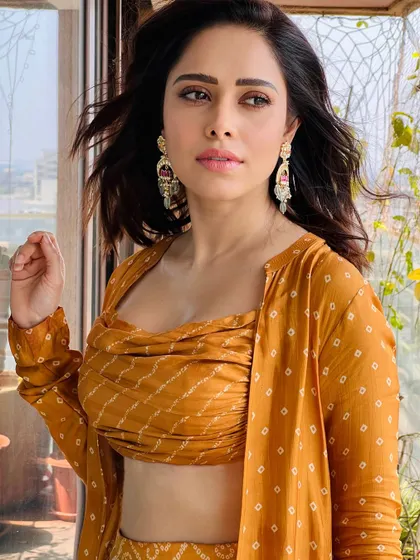 A closer look at this mustard yellow printed outfit. The wind-blown hair and statement earrings complete this effortless festive style.