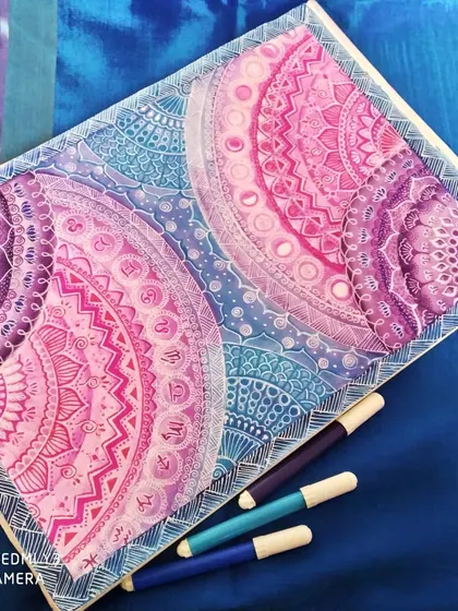 This is my 'Galaxy Mandala' series, where I blend intricate geometric patterns with the colors of deep space. Each section is carefully detailed with fine-line markers, transitioning from cosmic blues to vibrant purples and pinks to create a sense of depth and wonder.