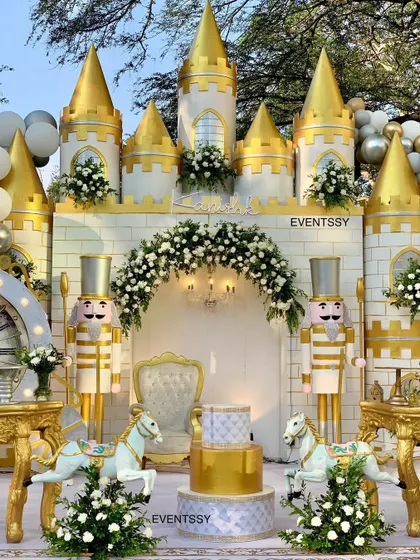 A grand and opulent royal prince celebration, featuring a full castle facade, life-sized nutcracker figures, and carousel horses.