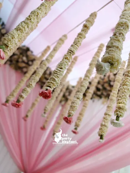 An upward-looking shot of the floral ceiling installation against the draped pink fabric, creating an artistic view of the traditional decor.