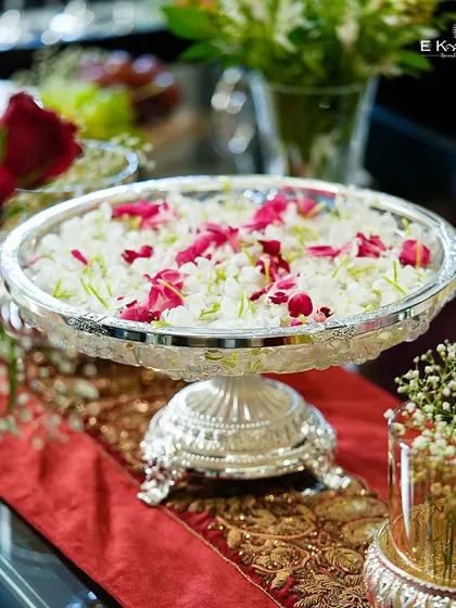 An urli is a timeless element of Indian decor, symbolizing prosperity and beauty. This silver-plated urli, filled with floating flowers, makes a perfect centerpiece for a wedding ceremony, adding a touch of traditional elegance.