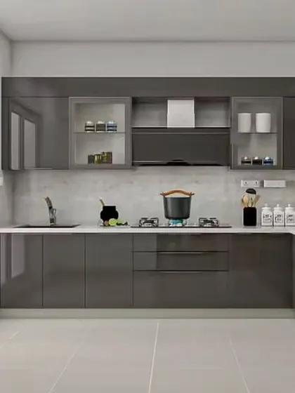 A contemporary L-shaped kitchen in a high-gloss grey finish that reflects light and makes the space feel larger. The design incorporates built-in appliances for a seamless, integrated appearance.
