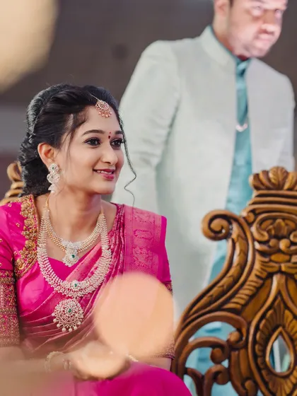 A candid shot of Surabhi during her Varapooja event. Her makeup is soft and pretty, with diamond jewelry adding a touch of sparkle to her bright pink saree.