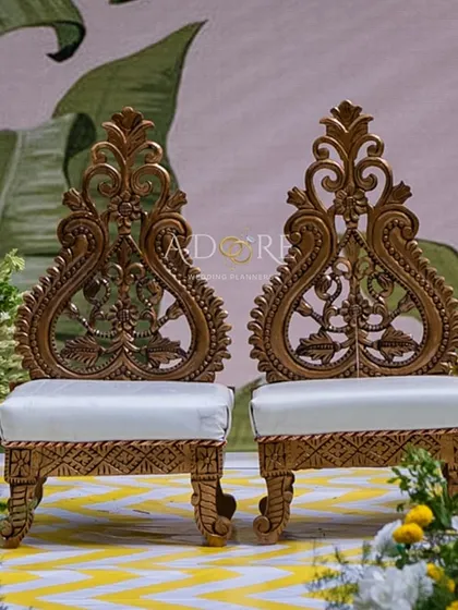 The centerpiece of the 'Banana Grove' theme: the couple's seating. These ornate, traditionally carved wooden chairs stand out against the custom backdrop, ready for the main ceremony.