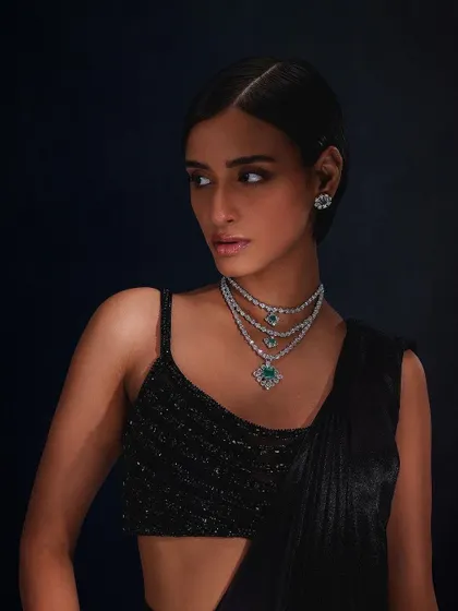 A sophisticated look for Purab Paschim, showcasing a triple-layered emerald and diamond necklace with matching studs.