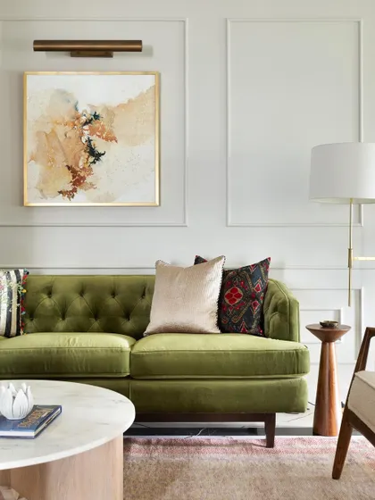The final living room in the Madras Home. Removing the wall that housed the old kitchen was a game-changer, flooding the space with light and creating a modern, elegant feel with an olive green sofa and classic moulding.