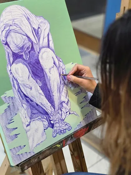 This close-up shot highlights the intricate cross-hatching technique used to create shadows and define the muscles on a figurative ballpoint pen drawing.