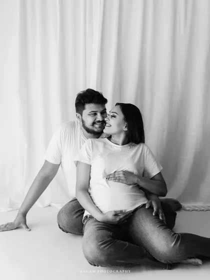 A simple and beautiful black and white portrait of an expecting couple. The monochrome tones enhance the intimacy and quiet joy of the moment.