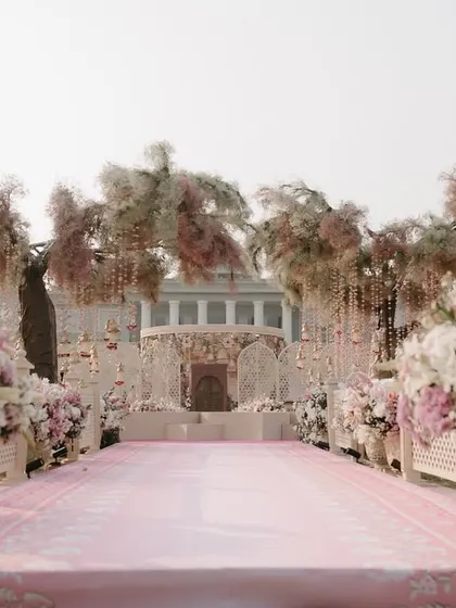 The view down the aisle towards the magnificent pink-themed mandap. We design the processional path to build anticipation and create a stunning visual journey for the bride and guests.