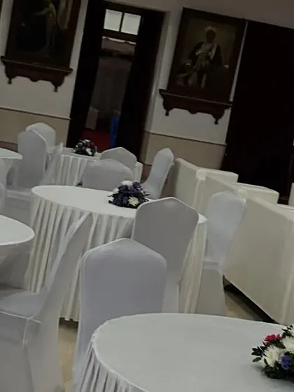 We manage all aspects of event seating and layout. This image shows the combination of lounge sofas and classic round tables with white linens and simple floral centerpieces for attendees.
