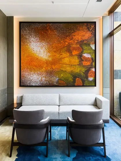 A large, abstract painting adding a burst of color and energy to a seating area at JW Marriott. This piece, inspired by geological processes, serves as a powerful statement in the hotel's curated art collection.