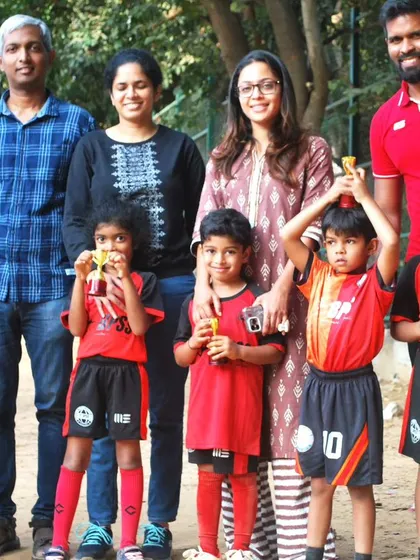 A wonderful group photo of our young players with their proud parents and coaches. I foster a community where families can share in the joy of their children's football journey.