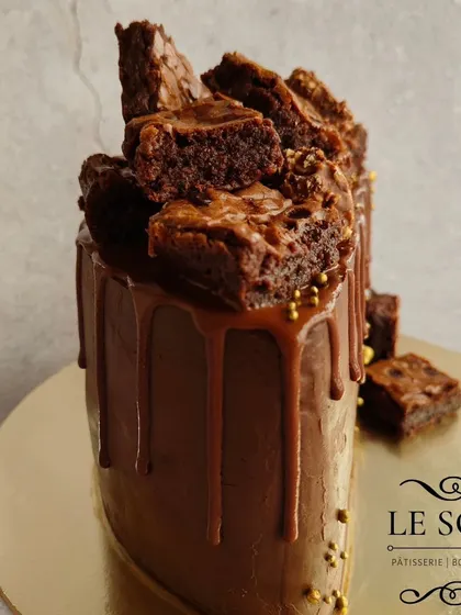 This semi-circle cake is a chocolate explosion. It's a 1 kg Ferrero Crunch cake with a ganache finish, Nutella drip, and a generous pile of my homemade Nutella brownies on top.