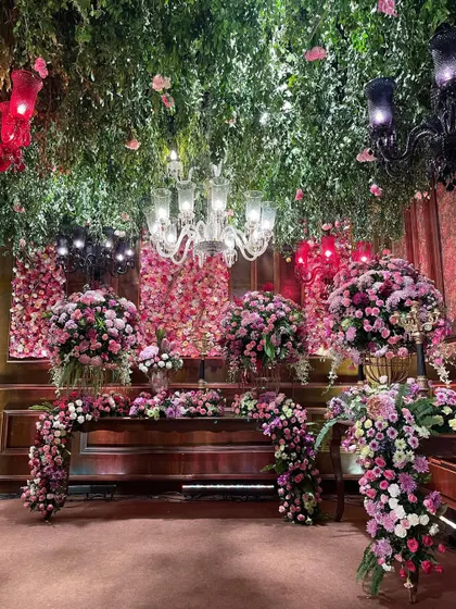 A view of the bar and lounge area, continuing the theme of floral abundance. The design integrated dramatic floral cascades and a lush green ceiling, ensuring every corner of the venue was part of the fairytale.