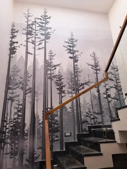 A dramatic, monochromatic forest mural installed along a staircase, creating a sense of height and modern sophistication.