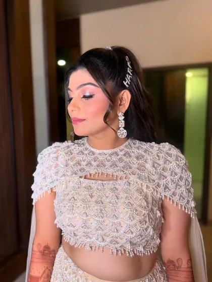A personalized touch for the bride's sangeet hairstyle. The custom "Hardik" hair clip adds a sweet, unique element to her chic and bouncy high ponytail.