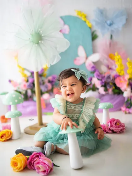 Playing with the polka-dotted mushrooms in her enchanted garden. These interactive props make the session fun for the little ones.