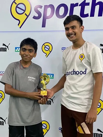 A proud moment as one of our junior players receives his champion's trophy from a tournament official.