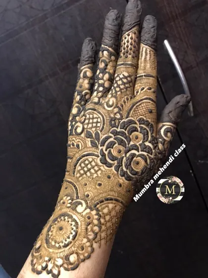 A dense and detailed design for the back of the hand, featuring a central floral motif.