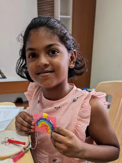 Look at the focus and pride on this young girl's face as she shows off the rainbow charm she made. It's a fantastic activity to boost confidence.