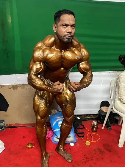 Holding the most muscular pose, focusing on tensing every muscle group to display the complete, conditioned package.
