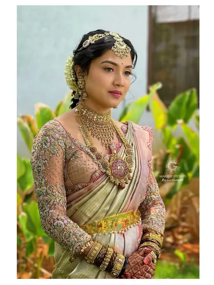 A three-quarter profile of Drutha, showcasing her beautiful traditional jewelry and the soft, romantic hairstyle we chose for her wedding day.
