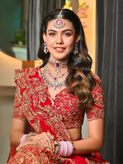 A closer view of the radiant bride in her red lehenga. The makeup is balanced to complement the intricate outfit and jewellery.