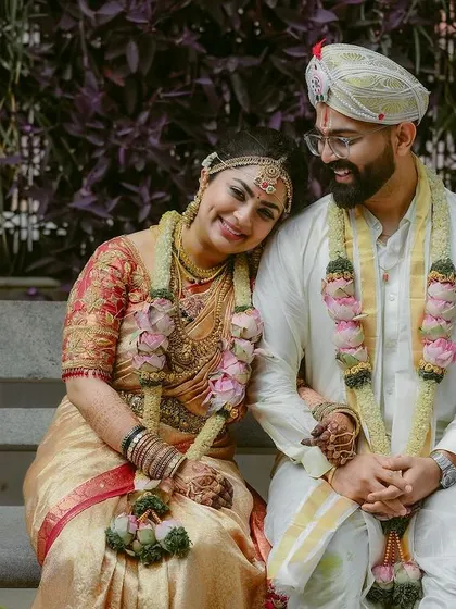 A relaxed and happy portrait of the couple seated on a bench, taking a quiet moment together amidst the day's festivities.