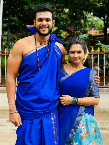 A full-length view of the blue Langa Davani, showing how it pairs beautifully with traditional male attire.
