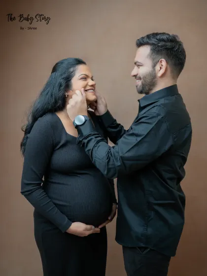 A playful and sweet moment between the couple. The partner gently pinches his wife's cheeks, bringing out a natural smile and capturing their fun-loving relationship.