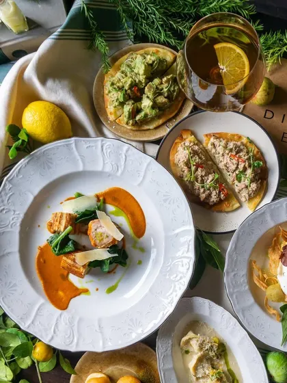 A closer look at the Italian spread, showing the beautiful plating of dishes like the Calabrian Chicken and Tuna Pizzette.