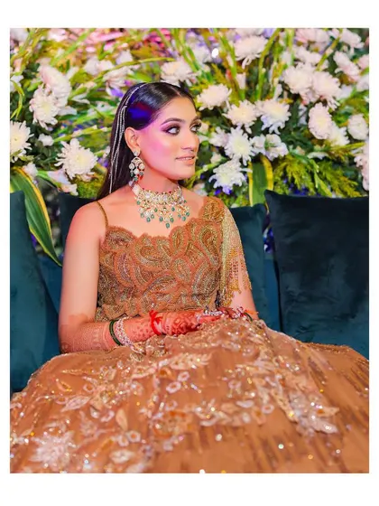 A serene portrait of the bride seated against a floral backdrop. Her elegant pose and the soft lighting create a calm and beautiful image.