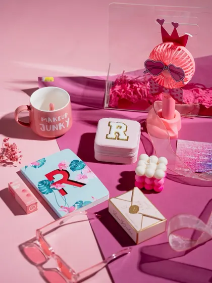 The 'Pretty in Pink' hamper deconstructed, showing off the 'Makeup Junky' mug, personalized notebook and coasters, and other fun, pink-themed items.