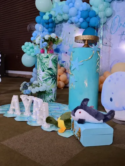 A low-angle shot showing the various props, including the marquee letters, whale cutout, and themed plinths, all arranged to create a layered, immersive scene.
