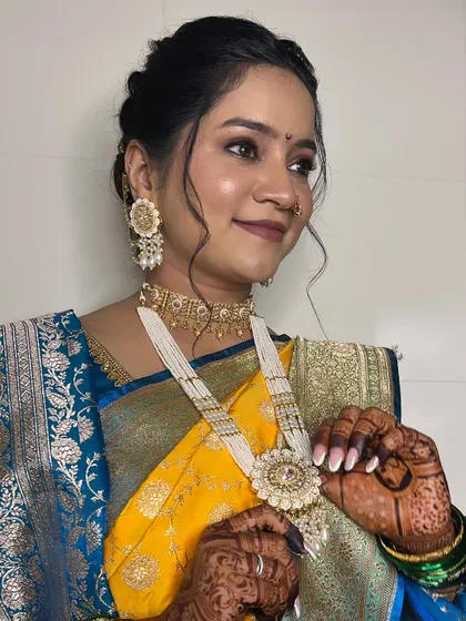 The bride adjusting her stunning pearl necklace. Every detail of her look is carefully coordinated.