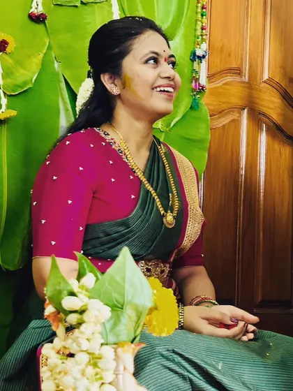 The joy of dressing up a bride and her bridesmaids. Here, the bride is in a lovely green and pink saree, with her friends surrounding her during a pre-wedding ritual.
