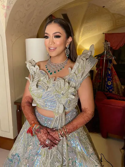 The bride looks stunning in her silver lehenga and elegant hairstyle.