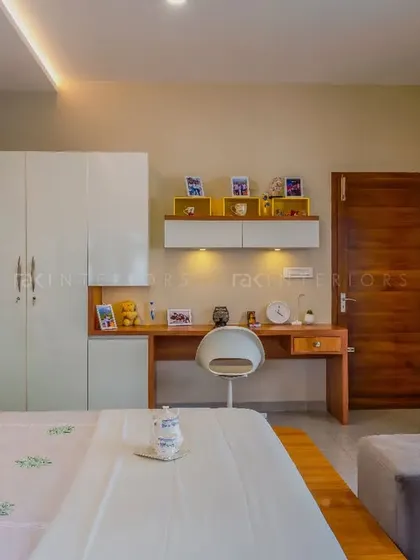 A bedroom that stands out for its simplicity. The floating bed design, white wardrobes, and integrated study desk create a clean, minimalist, and highly functional space.