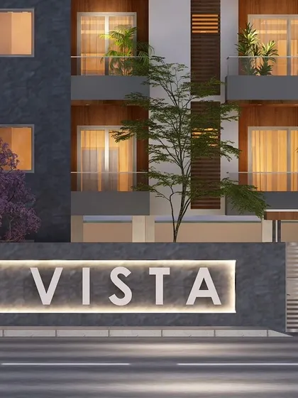 The illuminated signage for VN Vista at night, integrated into the modern compound wall design.