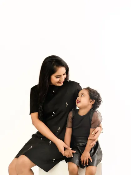 A look of pure adoration between mother and daughter. This candid moment, captured against a clean white background, is simple, beautiful, and full of love.