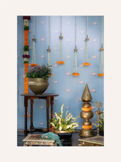 A corner detail from the Nishchitartham setup, showing the combination of traditional brass lamps, wooden furniture, and floral arrangements. Every corner is styled to perfection.