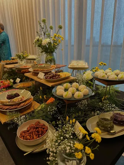 An elegant view of our festive grazing table, featuring beautifully arranged cheese platters, fruit, and desserts. The soft lighting and floral arrangements create a warm and inviting atmosphere.