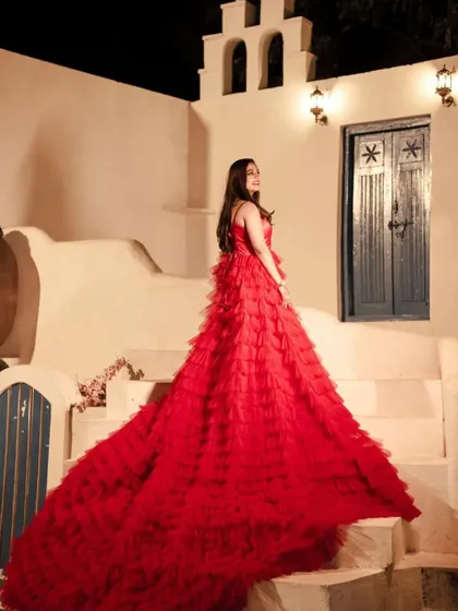 The long trail of this red ruffle gown cascades beautifully down the steps in this stylish pre-wedding photo.