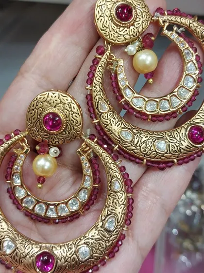 I also design standalone statement pieces. These gold-plated chandbalis with uncut Polki stones and ruby-coloured beads are a perfect example of how we can customize earrings to match the details of your outfit.