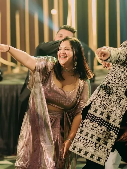 A candid shot of guests enjoying a dance performance, capturing the energy of the Sangeet night.