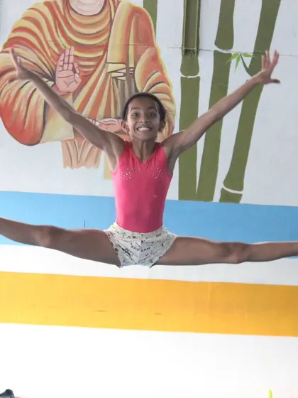 A dynamic split leap captured mid-air. This photo shows the power and grace we cultivate in our artistic gymnastics program.