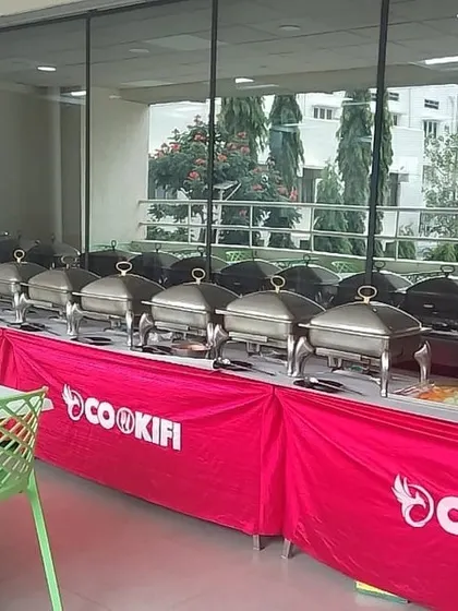 A full line of gleaming chafing dishes ready for a corporate event, reflecting our high standards of cleanliness and organization.