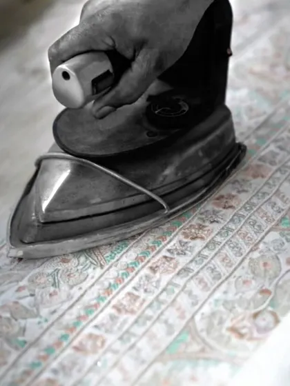 The heat of the iron sets the final shape. This is a crucial step in my process, where precision and care are applied to every inch of fabric, ensuring a flawless finish on every garment.