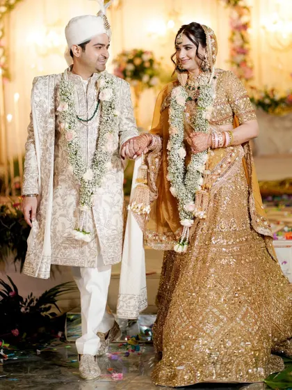 A classic portrait of the bride and groom walking hand-in-hand after their ceremony.