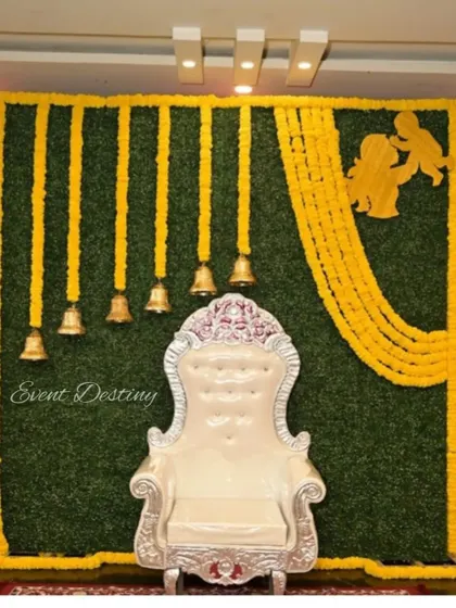 A simple yet elegant Seemantha backdrop. I used a green wall base and decorated it with hanging marigold garlands, brass bells, and a cutout representing the mother and child.